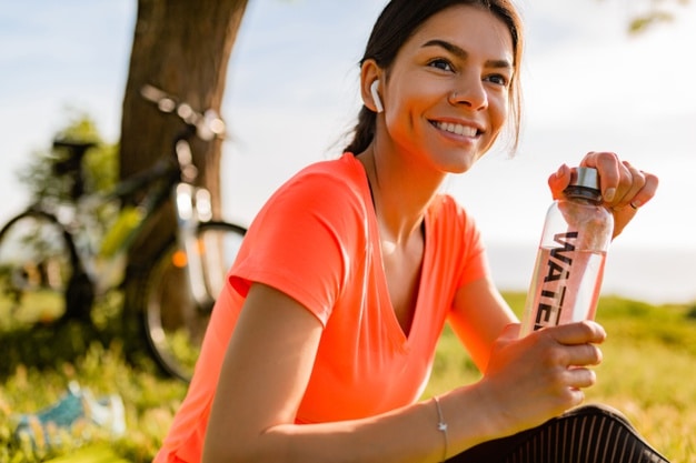 A person holding a water bottle and smiling

Description automatically generated