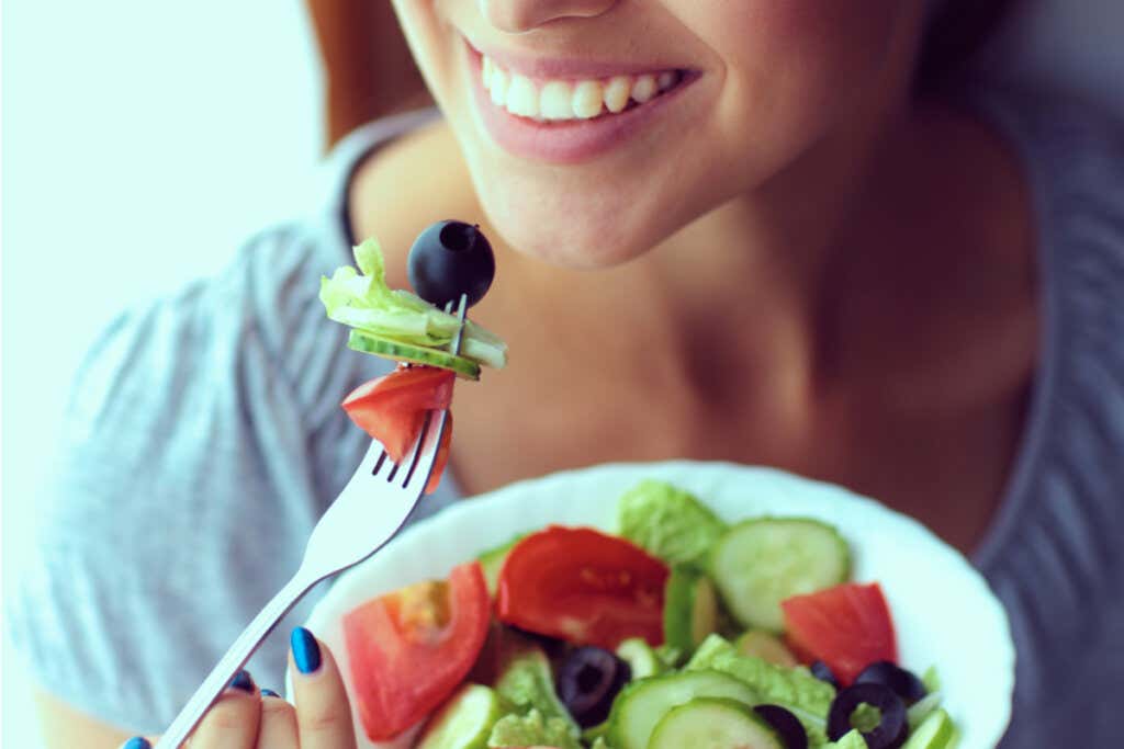 Mujer comiendo ensalada representando el vínculo entre Nervio vago y alimentación